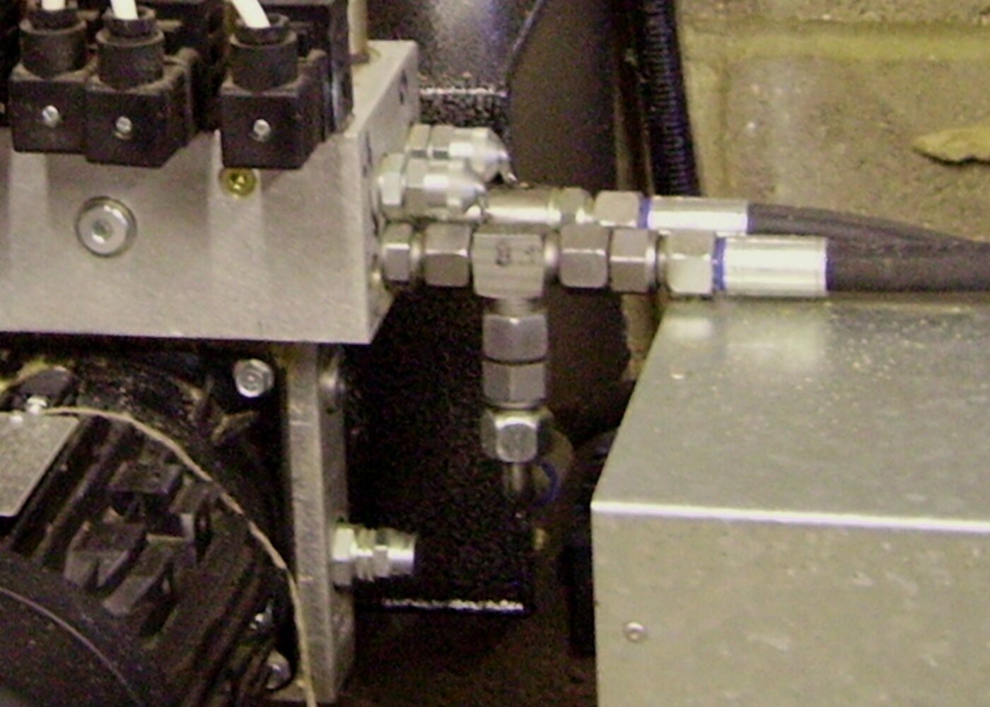 Hydraulic hose with a crimped steel fitting connected to a hydraulic block
